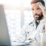 Medical-Coding-Services-a-male doctor reviewing reports for revenue cycle and ready to file complaints with insurances